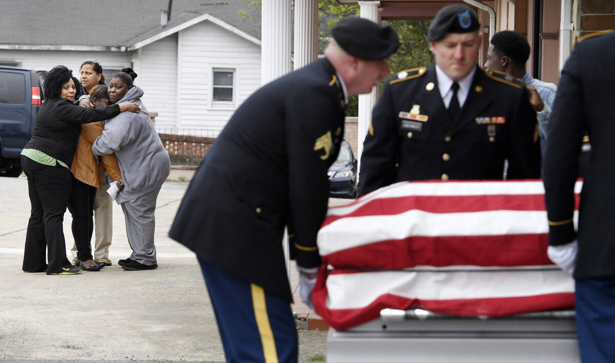 CaTesha Brown is consoled in March 2017 as the body of her son, Marquez Brown, arrives at Bentley & Sons Funeral Home in Macon. Brown was one of two Fort Stewart soldiers killed at a southeast Georgia apartment. Marshall's photograph won first place news photo from the Georgia Press Association.