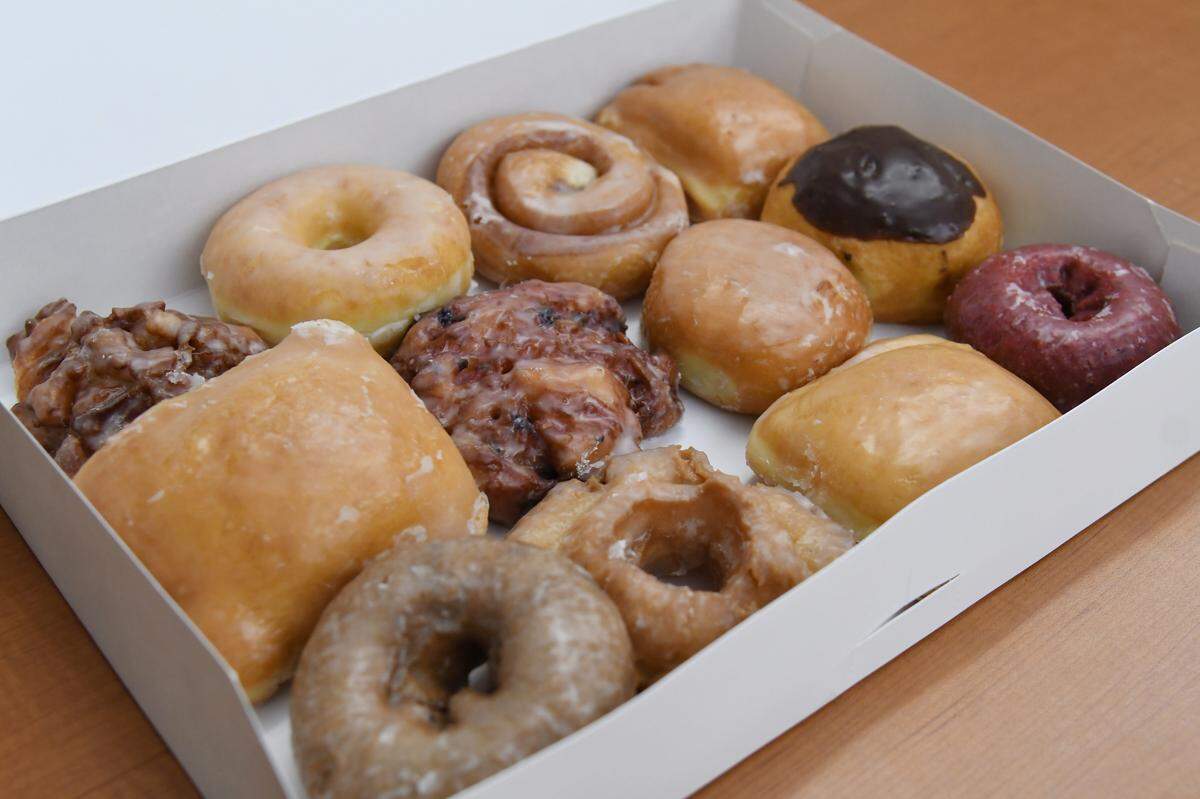 A dozen donuts from Ray’s Donuts sit on a table on Tuesday, Aug. 13, 2024, in Macon, Georgia. All of the doughnuts at Ray’s Donuts in Warner Robins are sold for 99 cents except the $3 maple bacon. The price is expected to remain at 99 cents through the end of the year.