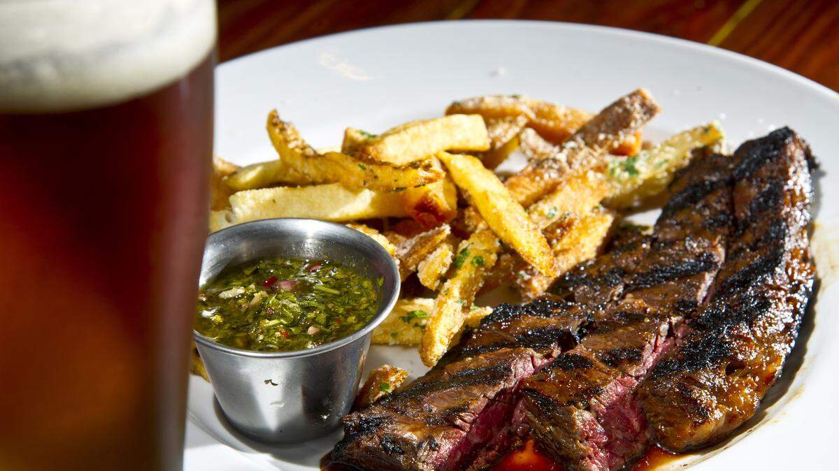 Marinated and grilled skirt steak is served with truffled fries and chimichurri sauce at Bearfoot Tavern.