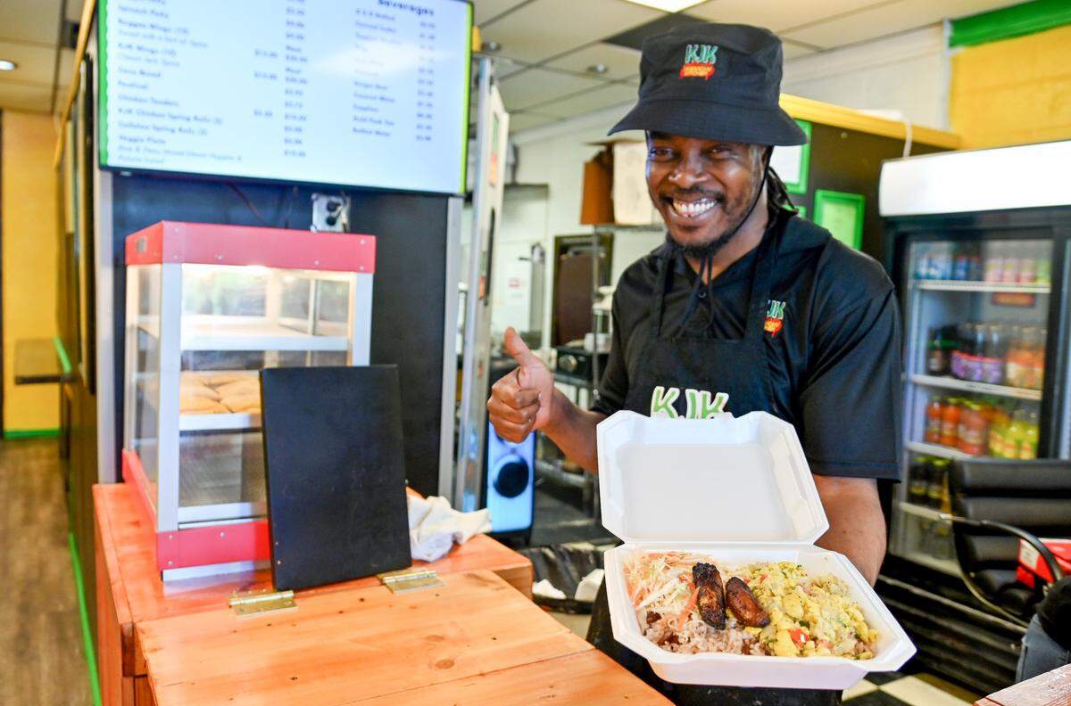 Owner and Chef Kirk Henry holds up a plate of ackee and salt fish at KJK Jamaican Kitchen at 3348 Vineville Ave. in Macon.