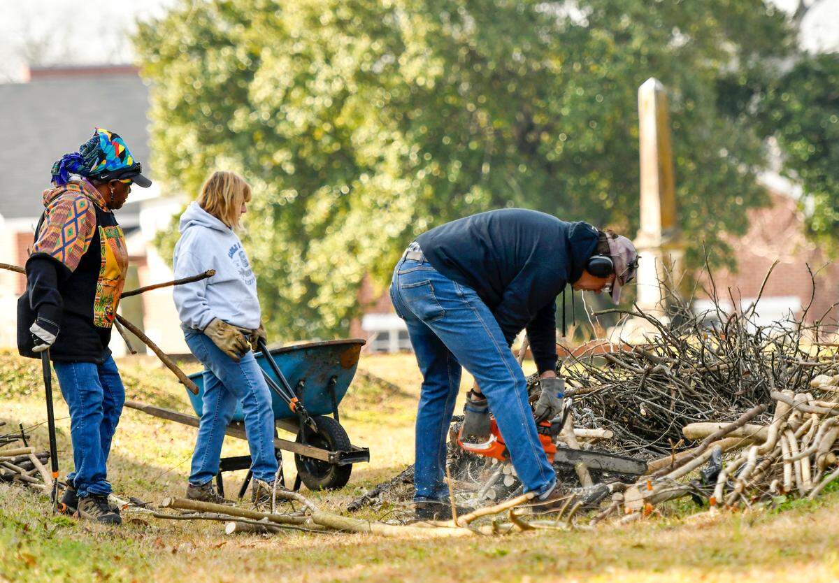 Alice Jackson with the Macon Cemetery Preservation Corporation along with volunteers Kevin and Lynn Gunnerman cut and pile up wood at Linwood Cemetery Saturday Feb. 12.