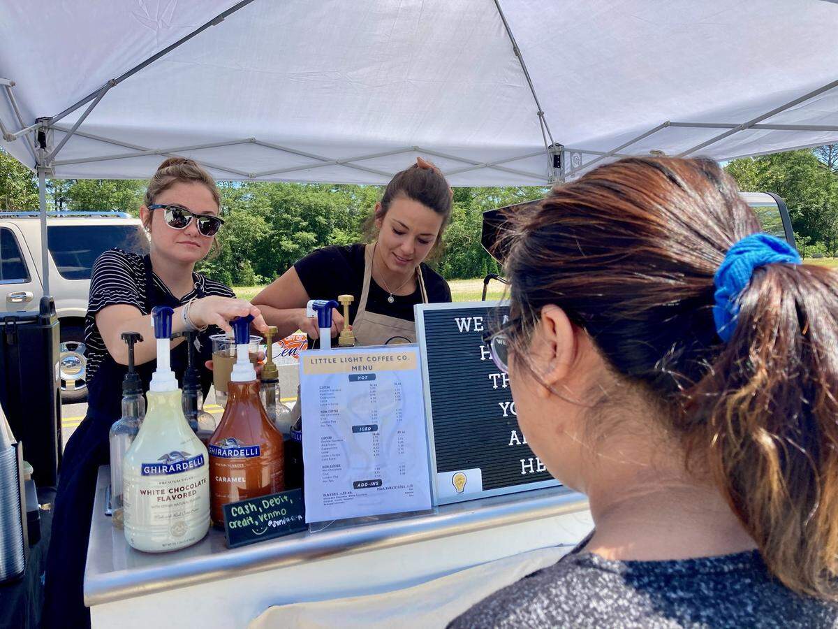 Olivia Mattingly, left, and Sophia Smith, owner of Little Light Coffee Co., prepare an order at a farmers market held at Center Park at Centerville in this 2021 Telegraph file photo. The business started as a mobile espresso bar.