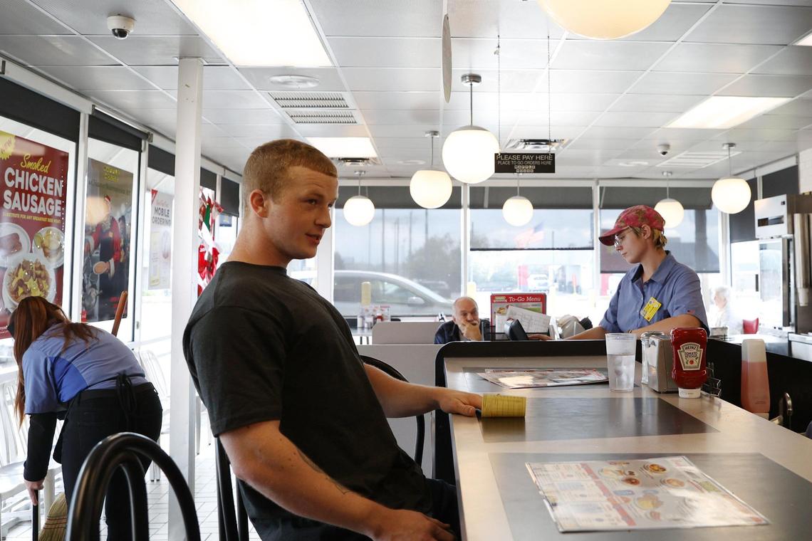 Jackson Meeks, 19, sits on the counter at the southbound Waffle House in the morning of Sunday, Feb. 2, 2025, in Byron, Georgia. Although they’re not the two closest Waffle Houses in Georgia, the Exit 49 Byron Waffle Houses sit just 0.3 miles apart on the same road.
