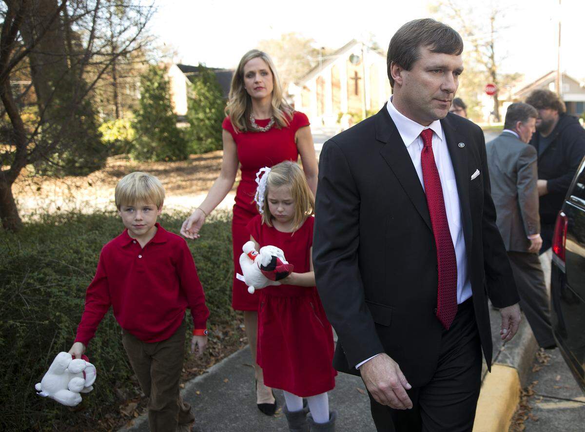 Alabama defensive coordinator Kirby Smart is followed by his wife Mary Beth and seven-year-old twins Weston and Julia to a waiting car after a press conference where he was introduced as Georgia’s new NCAA college head football coach Monday, Dec. 7, 2015, in Athens, Ga.