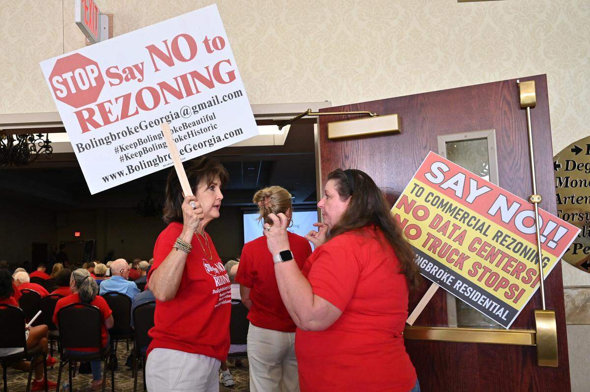 Bolingbroke resident Terri Campbell (left) speaks to an attendee before the start of Monroe County Planning and Zoning board public hearing at the Monroe County Conference Center on Monday, July 28, 2025, in Forsyth, Georgia. The Monroe County Planning & Zoning Board voted unanimously Monday evening against rezoning about 900 acres of land for the project. 