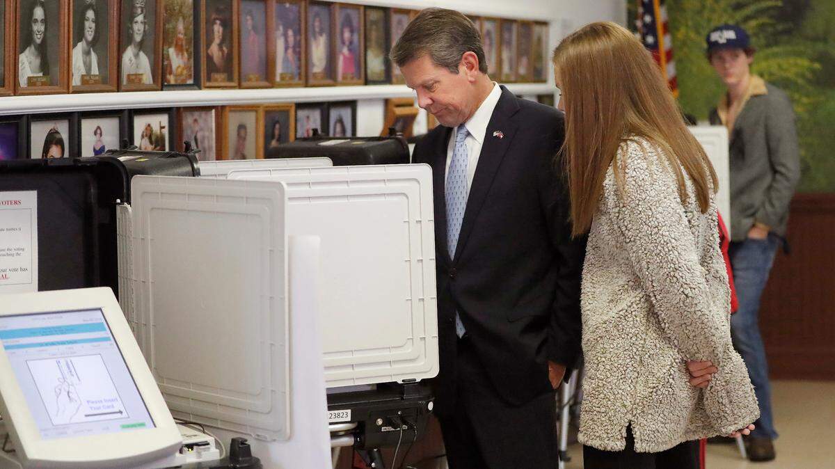 Georgia Republican gubernatorial candidate Brian Kemp casts his ballot as his youngest daughter Amy Porter looks on Tuesday, Nov. 6, 2018, in Winterville, Ga. Kemp is in a close race with Democrat Stacey Abrams.