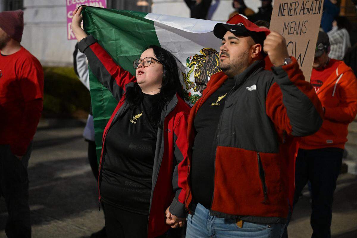Breanna and Arturo Aguilar, from Warner Robins, Georgia, hold a Mexican flag during the March on Macon on Wednesday, Jan. 28, 2026, in Macon, Georgia. Arturo Aguilar said he is a first-generation Mexican-American. 