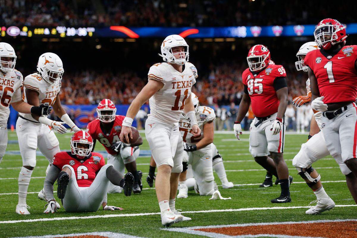 Texas quarterback Sam Ehlinger (11) reacts after scoring a touchdown, between Georgia linebacker Natrez Patrick (6), defensive lineman Devonte Wyatt (95) and linebacker Brenton Cox (1) during the first half of the Sugar Bowl NCAA college football game in New Orleans, Tuesday, Jan. 1, 2019. (AP Photo/Gerald Herbert)