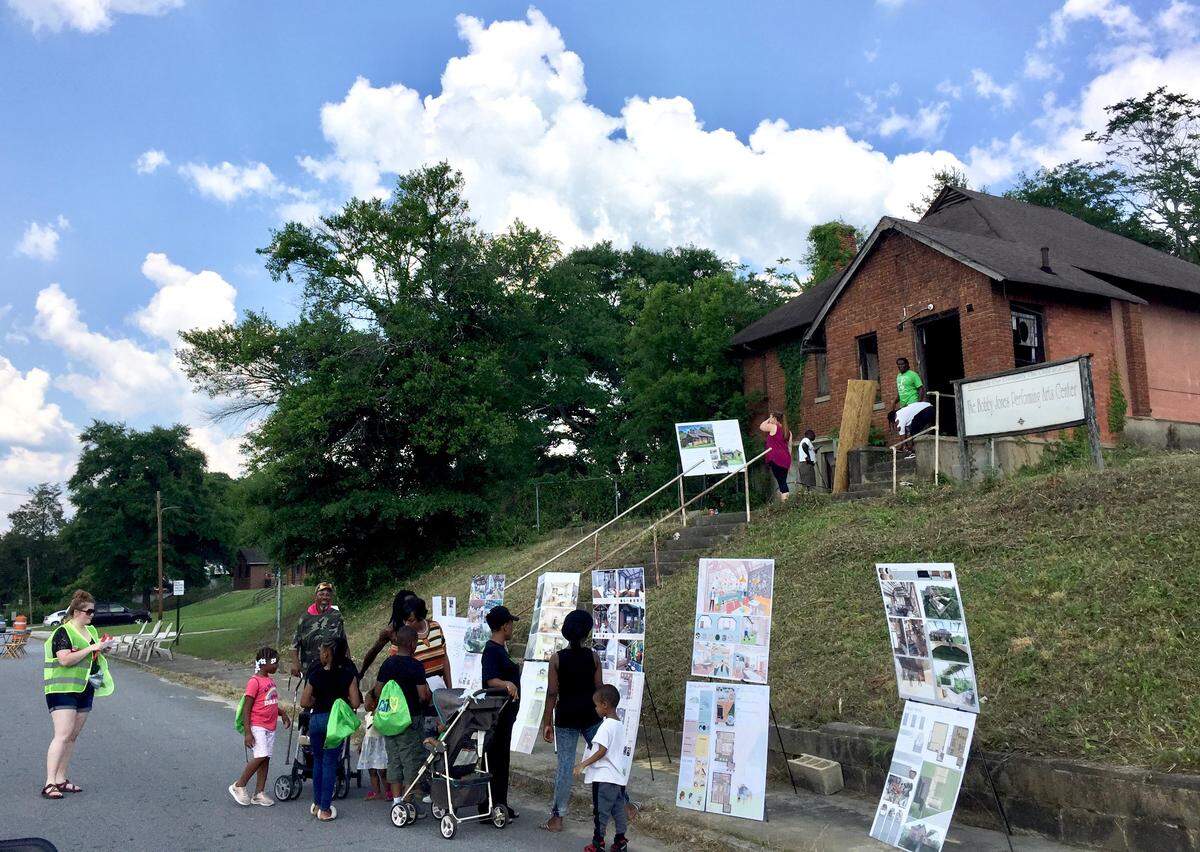 Visitors look over proposals for a new use for the vacant Bobby Jones Performing Arts Center on Monroe Street at a block party on May 19, 2019.