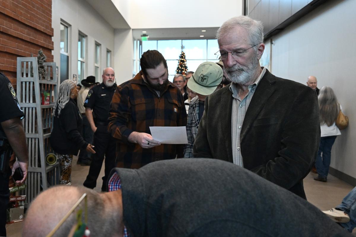 Johnnie Powell, from Monroe County (right), waits in line to sign a petition opposing a proposed data center in Forsyth outside a city Planning & Zoning meeting on Monday, Dec. 22, 2025, at Forsyth City Hall in Forsyth, Georgia. Dozens of people aiming to attend a Forsyth Planning & Zoning meeting gathered in the lobby outside after the meeting room reached capacity. 