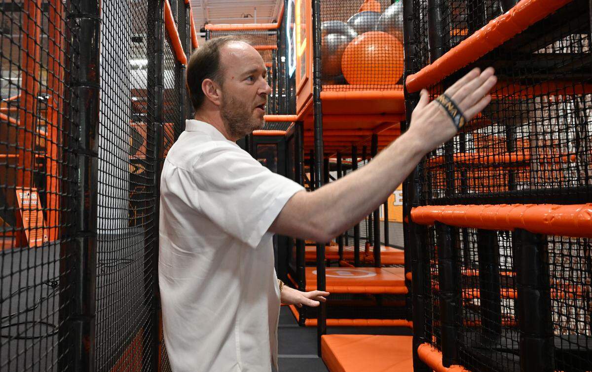 Big Air Warner Robins franchise owner Dustin Pelletier walks through one of the park’s attractions Arena X before on Tuesday, March 17, 2026, ahead of the park’s in Warner Robins, Georgia. The attraction involves using an RFID wristband as players navigate 25 obstacles searching for beacons and scanning them to accumulate points.