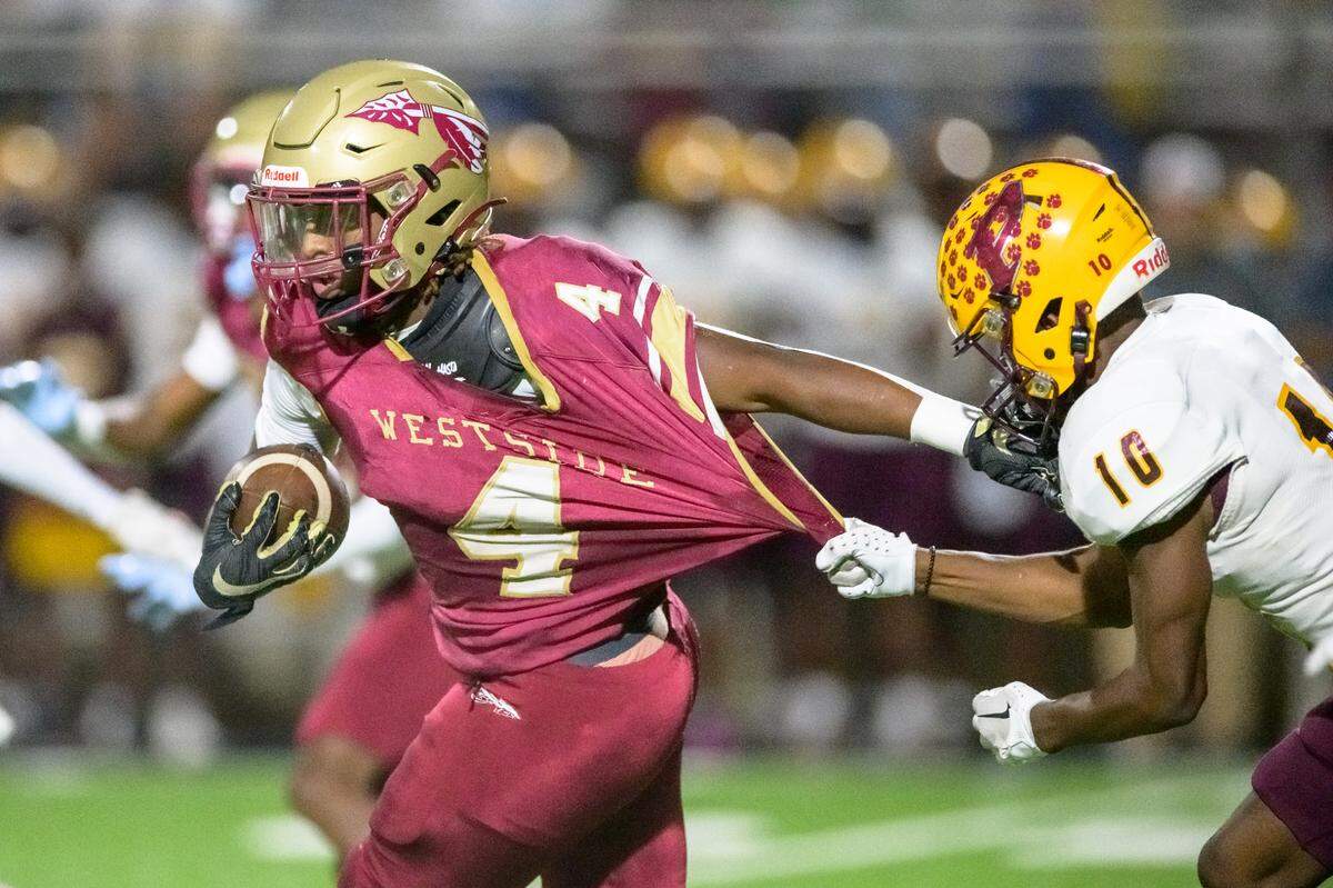 Westside running back Kadiphius Iverson pulls away from Perry defender Jerrel Pinckney in action Friday night at Ed Defore.