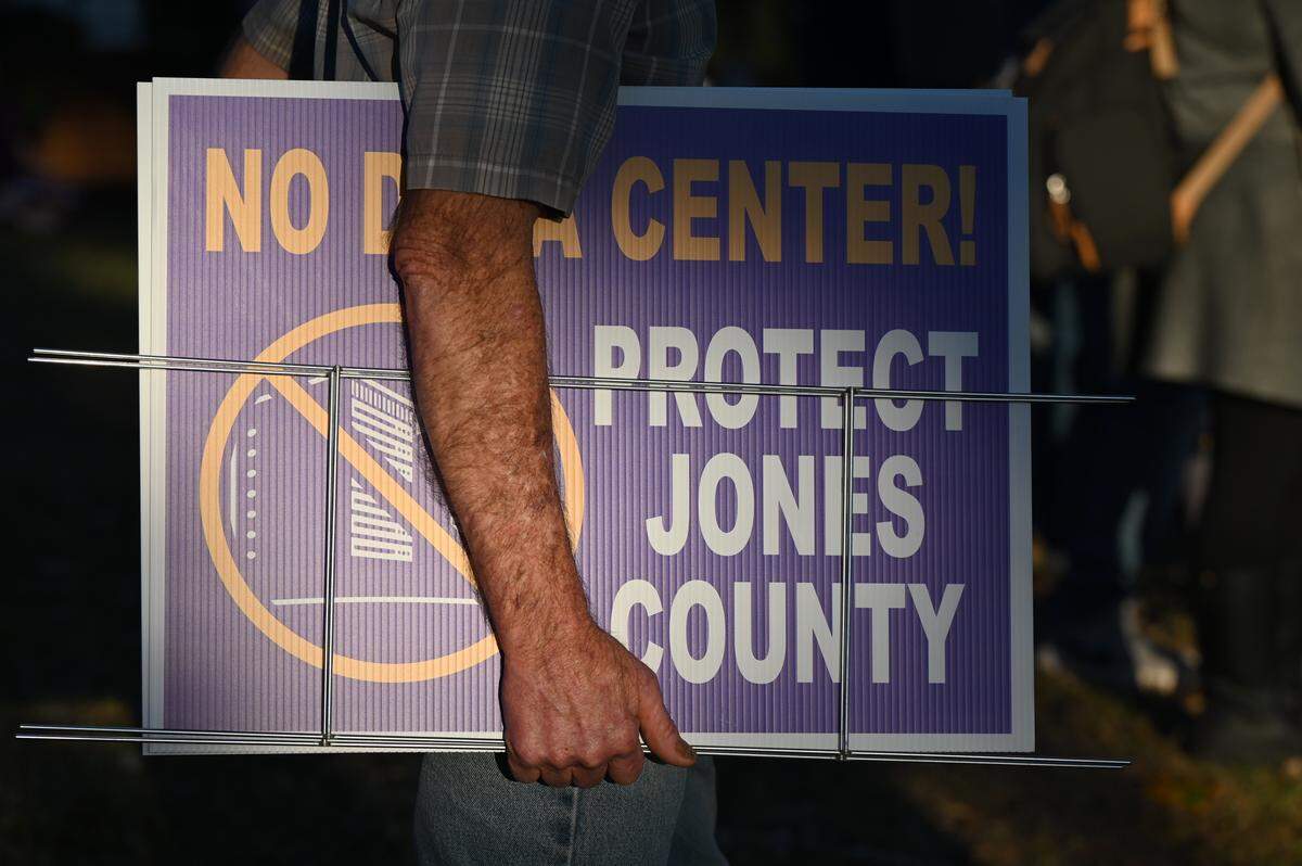 A meeting attendee holds a “No Data Center” yard sign, which were sold ahead of the Jones County data center informational meeting on Wednesday, Oct. 15, 2025, in Gray, Ga. The meeting was organized by residents opposing a potential data center ahead of a county Planning and Zoning meeting that plans to decide the fate of a proposal to rezone agricultural land in the county to commercial.