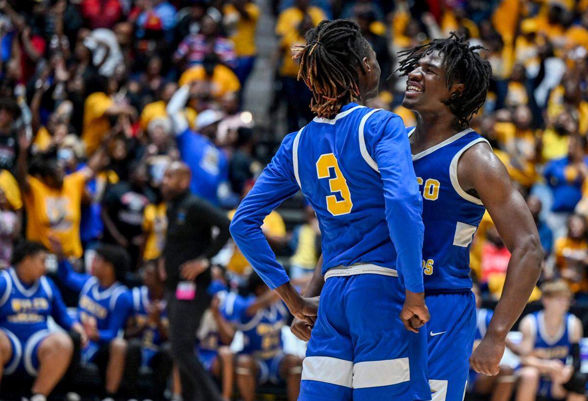 Wilkinson’s Jordan Jackson (23) and Treveon Evans (3) celebrate in the final seconds of the Warriors’ 40-36 GHSA 1A D-II championship against Charlton County Wednesday in Macon.