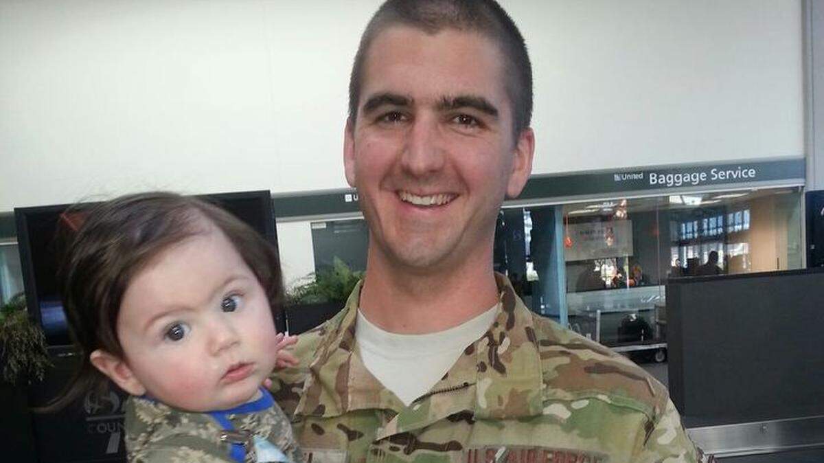 Matthew Heath holds his son Levi after returning home from Afghanistan in October 2013 in the Sacramento airport.