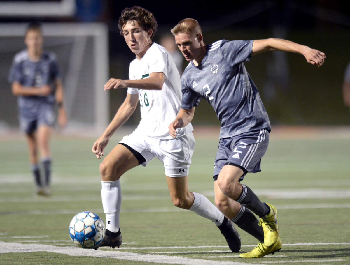 GMC center back Avery Kirkland (2) and ACE midfielder Tanner Moreau (10) battle for the ball during their GHSA 1A State Championship match Friday night at Mercer.