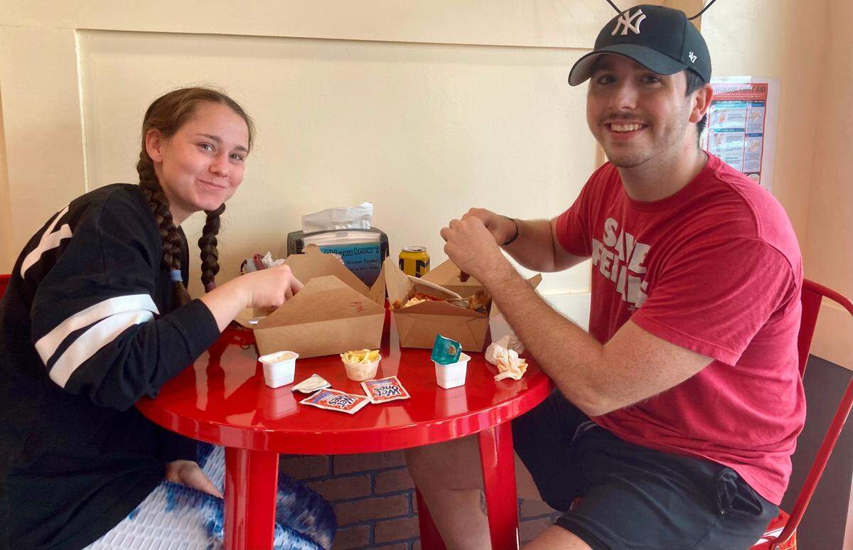 Isabella Casanova and Jonathan Braxton each enjoy the No. 2 combo at the grand opening Wednesday of No Name Chicken in Warner Robins.