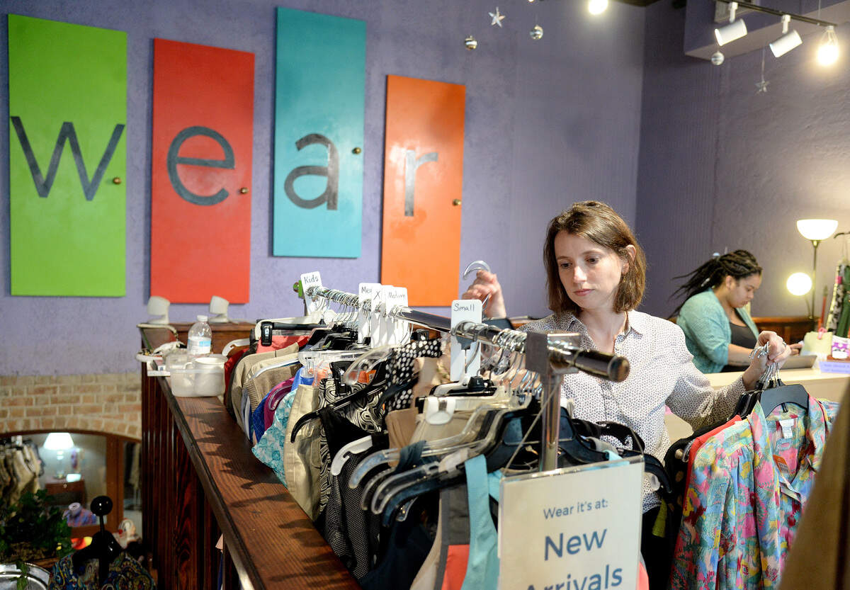 Wear manager Heatherly Wakefield grabs clothes off a new arrivals rack Tuesday to move to other racks throughout the store. The consignment store owned by Depaul USA benefits Daybreak, a resource center that provides a range of services to MaconÕs homeless residents.