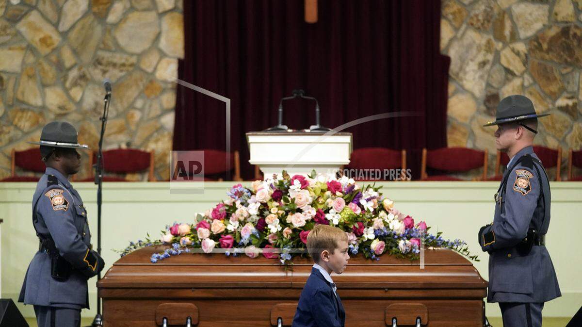A young mourner walks past the casket before the funeral service for former first lady Rosalynn Carter at Maranatha Baptist Church, Wednesday, Nov. 29, 2023, in Plains, Ga. The former first lady died on Nov. 19. She was 96.