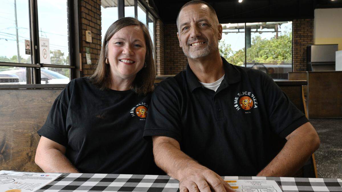 Home Slice Pizza owners LeAnn and Paul Register pose inside of the restaurant on Tuesday, Aug. 26, 2025, in Perry, Georgia. The husband and wife duo opened the pizza restaurant in July and aim to create a gathering place for the Perry community.