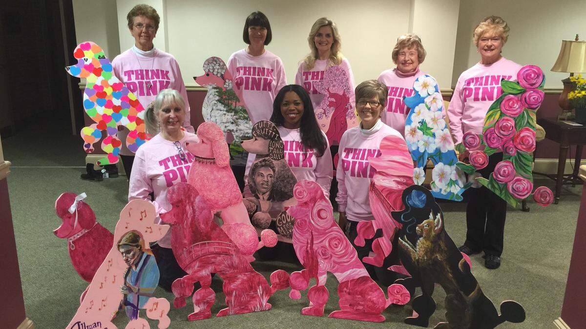 Members of the Think Pink Committee show a sampling of wooden pink poodles that have been decorated for this year's Cherry Blossom Festival. Some of the poodles will be raffled off at festival events.
