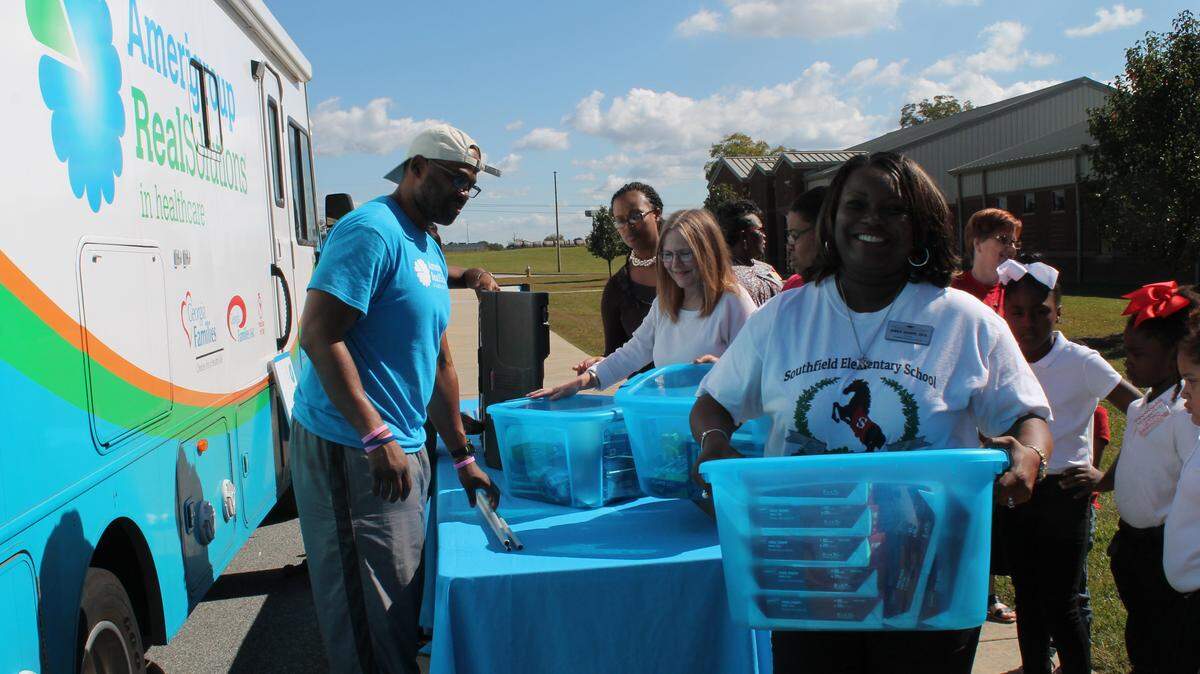 Southfield Elementary School Principal Janice Sharpe smiles after picking up a bin full of school supplies from the Amerigroup Community Outreach vehicle Friday afternoon.