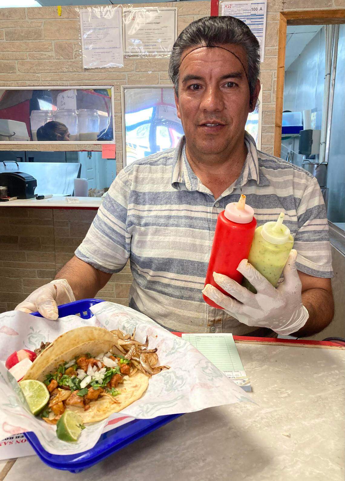 Samuel “Sammy” Naranjo serves up tacos and two made fresh salsa choices: a hot sauce made with dried red chili peppers and a mild sauce made with avacados.