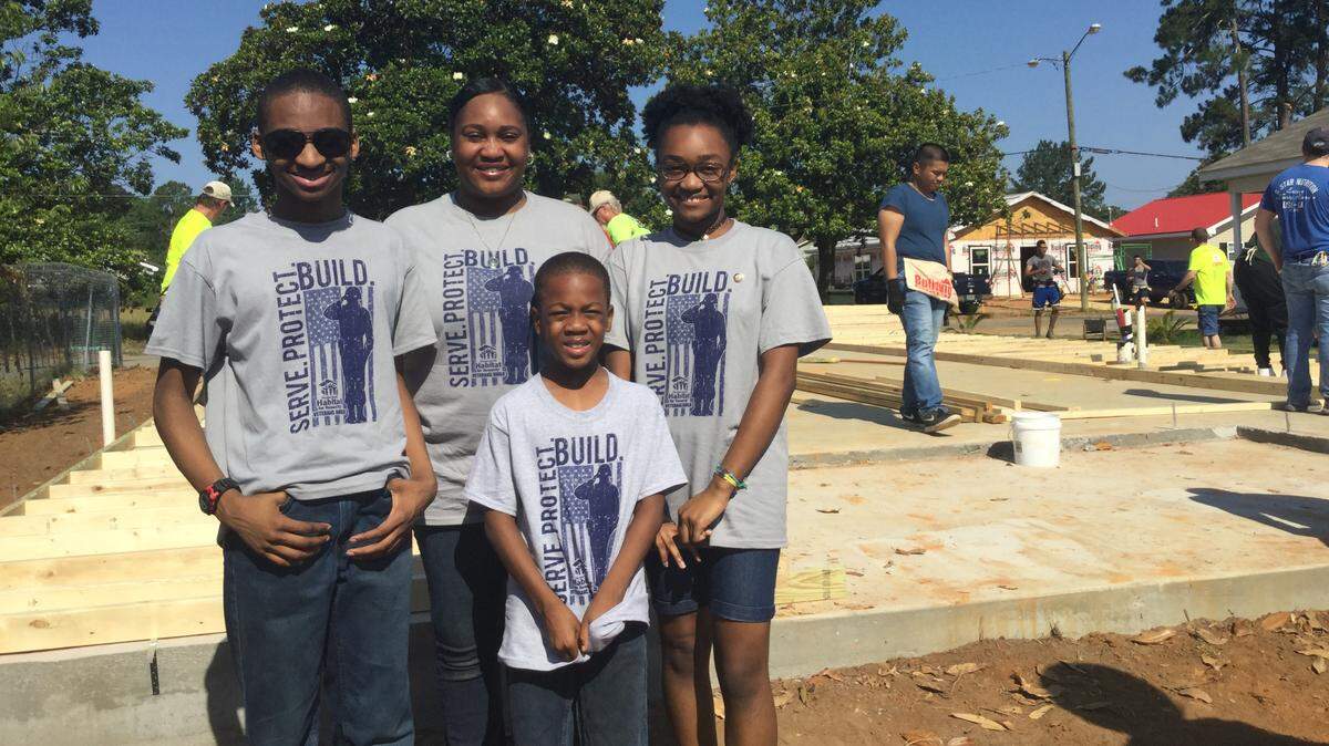 Ayanah Gaines, a member of the U. S. Army Reserve, with her children Antoine, 15, Ayanah, 14, and Peyden, 8, at the construction site for their new home, the Habitat for Humanity’s 60th house build in Houston County. The home is being built on Old Mission Way in Warner Robins.