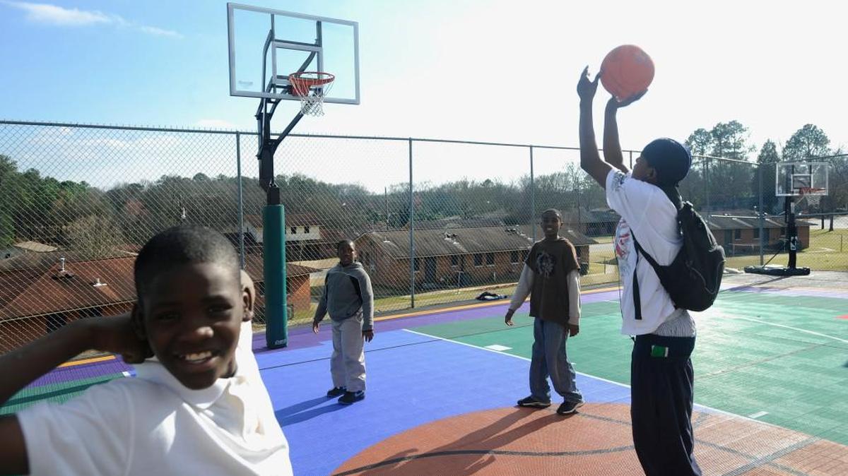 Left to right, Trayvon Tuff, Labrandon Anderson, Armani Glover and Drake White play basketball outside the Motivating Youth Foundation afterschool program in Davis Homes in Macon in 2015.