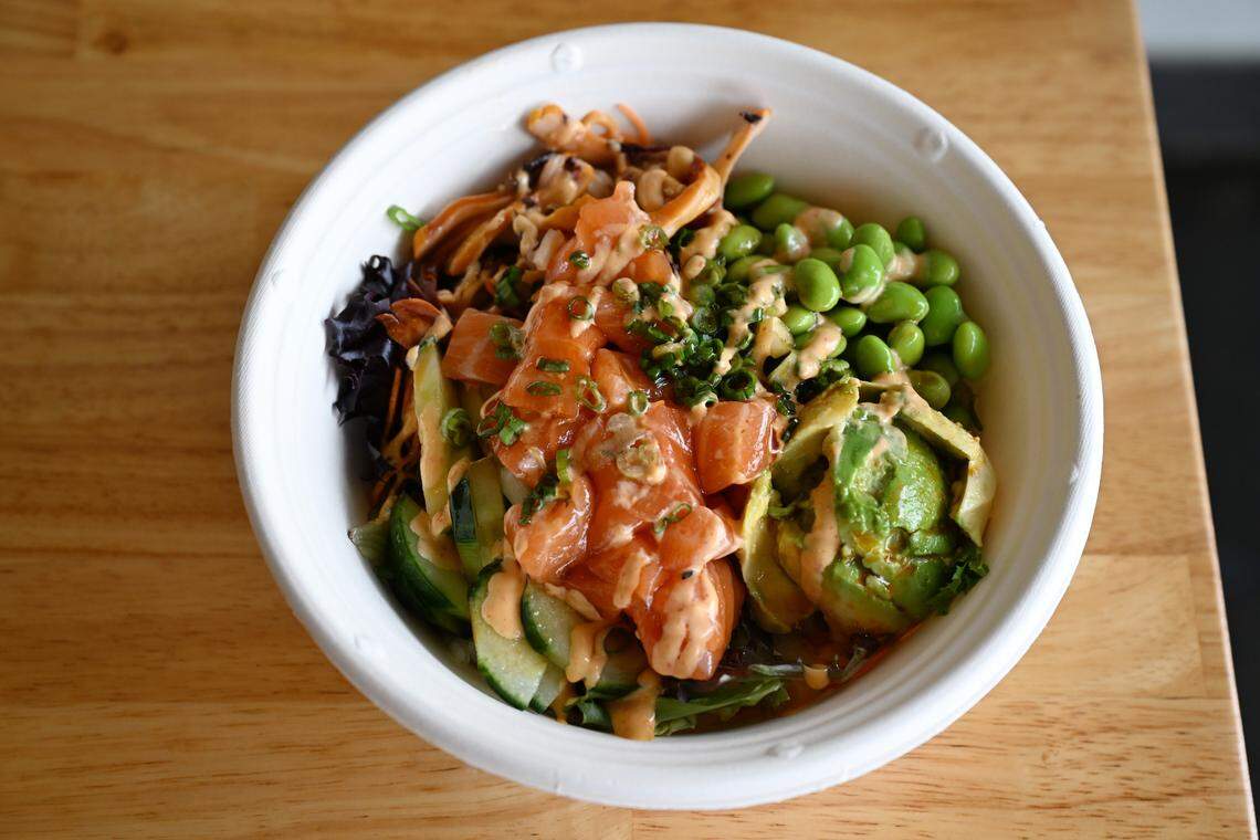 A raw salmon poke bowl from the new Robins Poke & Ramen with edamame, cucumber, avocado and other ingredients. The build-your-own bowl format allows customers to customize their poke bowls with different protein, vegetables, sauces and toppings.