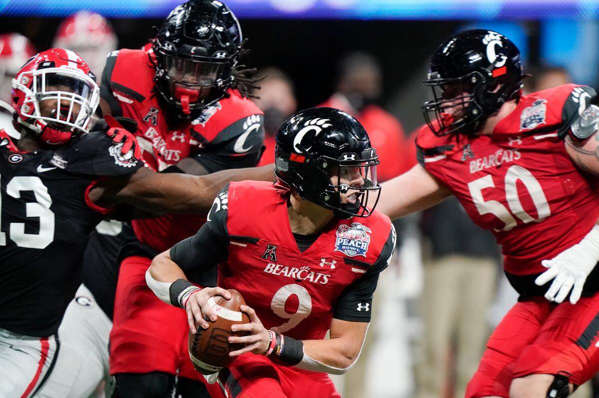 Cincinnati quarterback Desmond Ridder (9) runs out of the pocket against Georgia during the first half of the Peach Bowl NCAA college football game, Friday, Jan. 1, 2021, in Atlanta. (AP Photo/Brynn Anderson)