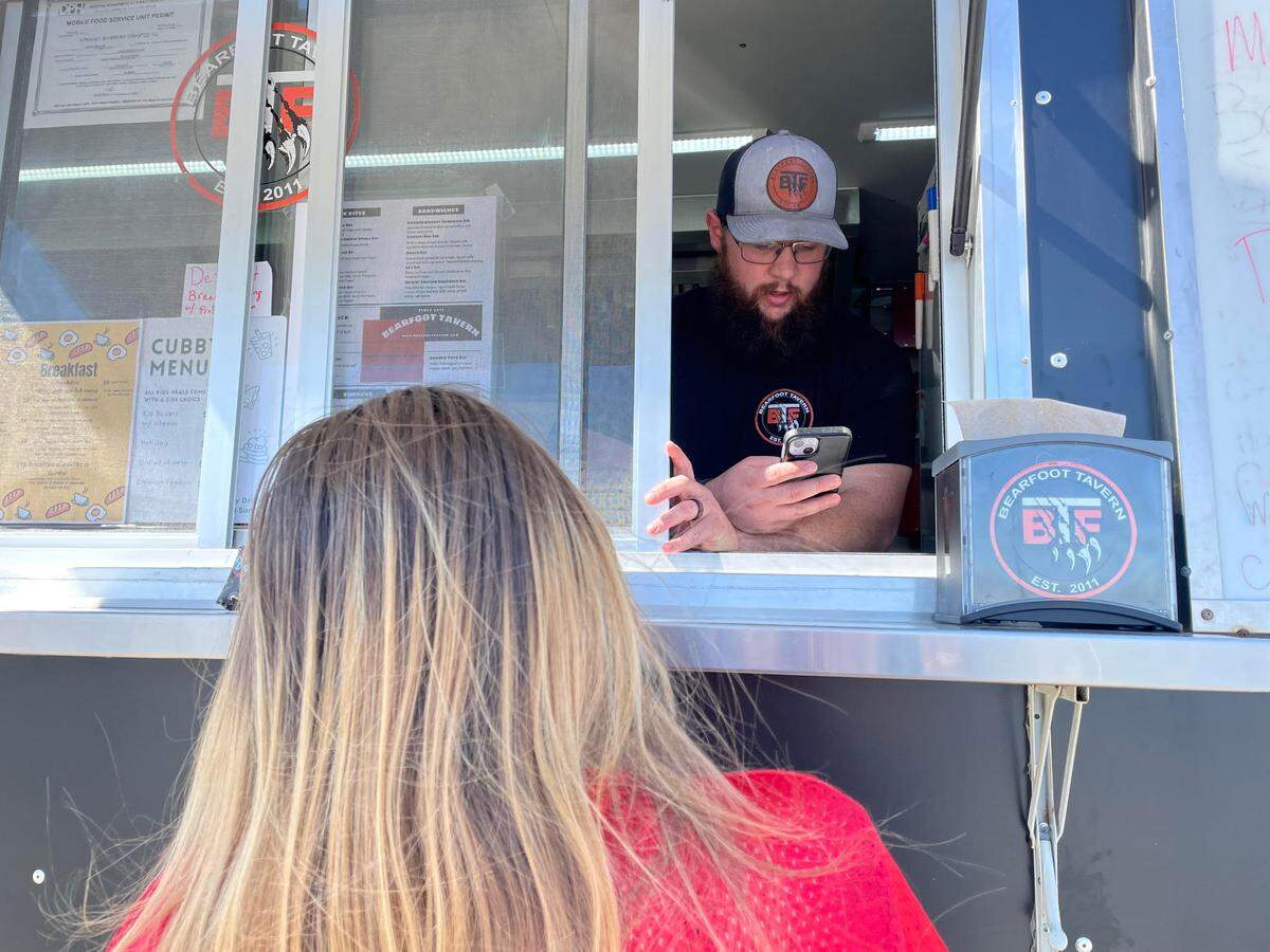 Mark Bell, general manager of the downtown Macon’s Bearfoot Tavern, takes an order from Danyell Smith at the Irish gastropub’s food truck set up in the parking lot of Lowe’s Home Improvement in Warner Robins on Wednesday, February 26, 2025.