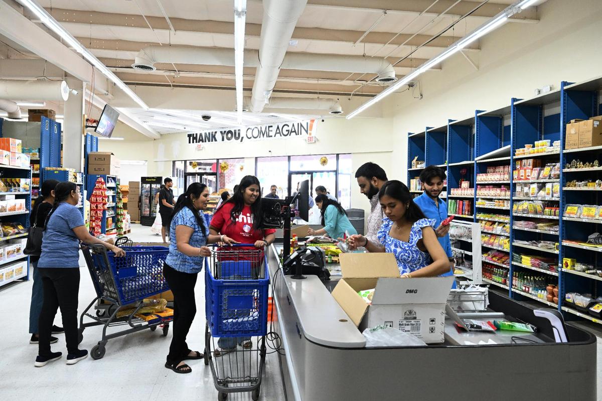 Members of the five families that co-own the Maharaja Market, a new Indian-Pakistani grocery store, check out and box goods on Wednesday, April 16, 2025, during the store’s grand opening in Warner Robins.