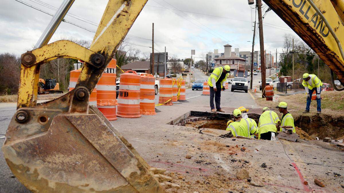 Georgia Department of Transportation workers dig out dirt while repairing a sinkhole Wednesday afternoon along Hardeman Avenue in Macon.