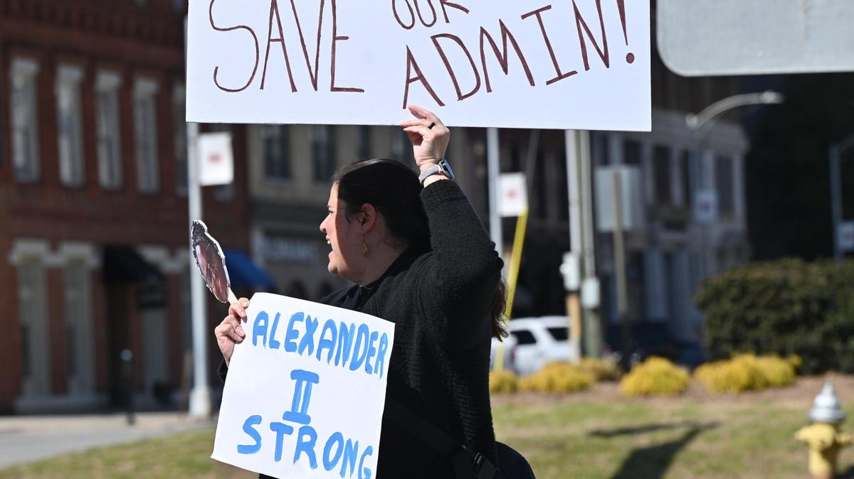 Alexander II Elementary School PTA member Nidia Svare holds a sign on the corner of 3rd Street and Mulberry Street on Friday, March 7, 2025, in downtown Macon, Georgia. A small but vocal group of parents and community members protested on Friday afternoon calling for the Bibb County school district to give answers as to why the Alexander II Elementary Schools principals’ contracts were not extended.