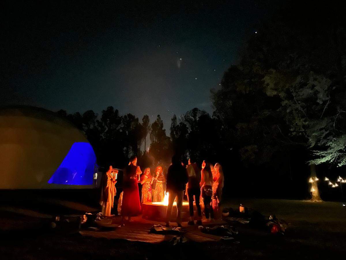 Guests enjoy an evening around the fire pit at retreat and event venue business The Florrest located in Hillsboro, GA.