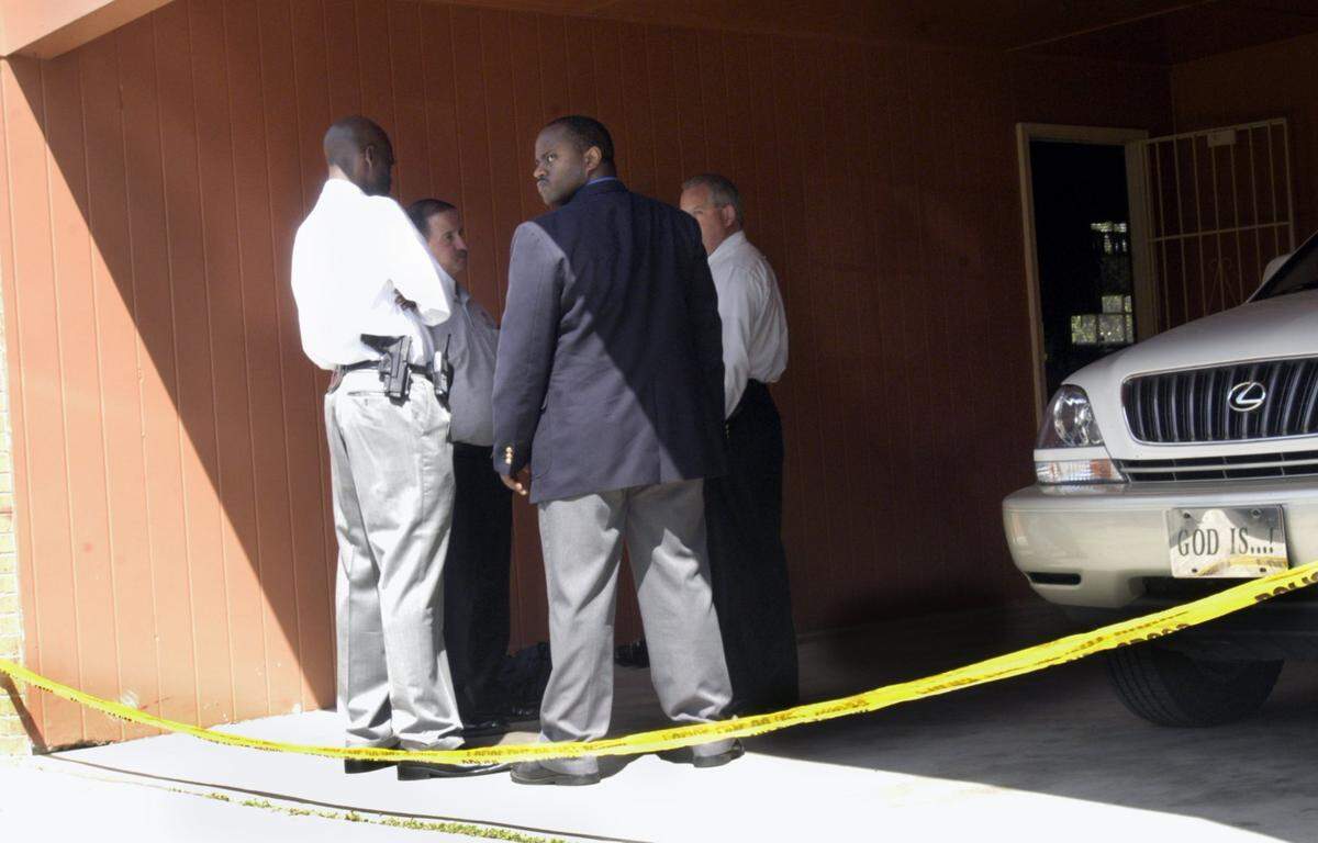 Macon police detectives at the scene where Michael Glover was killed by a gunman at Glover’s house on Anthony Road the night of March 29, 2004.