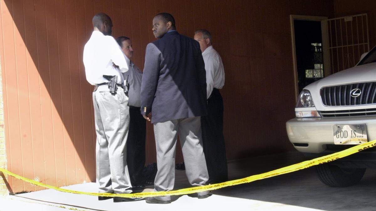 Macon police detectives at the scene where Michael Glover was killed by a gunman at Glover’s house on Anthony Road the night of March 29, 2004.