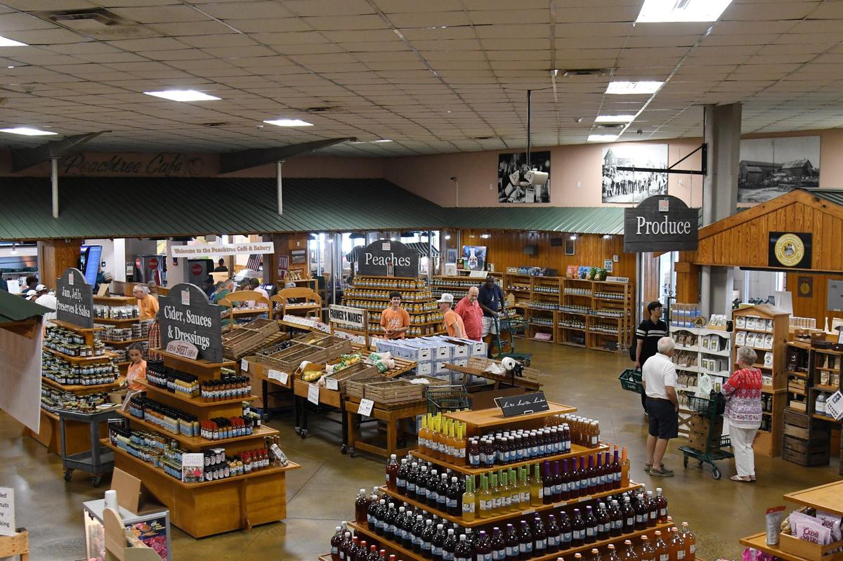 Shoppers and employees walk through Lane Southern Orchards on Thursday, July 18, 2024, in Fort Valley, Georgia. Lane Southern Orchards serves 300,000 visitors a year with peaches as the roadside stop’s main attraction.