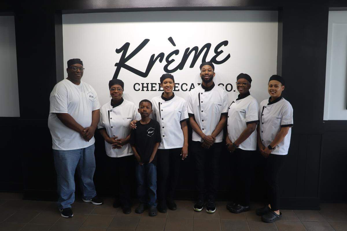 Brandon Brown (center wearing glasses and buttoned chef coat) stood with his family and friends who work at his new dessert shop, Krème Cheesecake Co., on April 2, 2025, at 4590 Billy Williamson Drive Suite 101 in Macon, Ga.