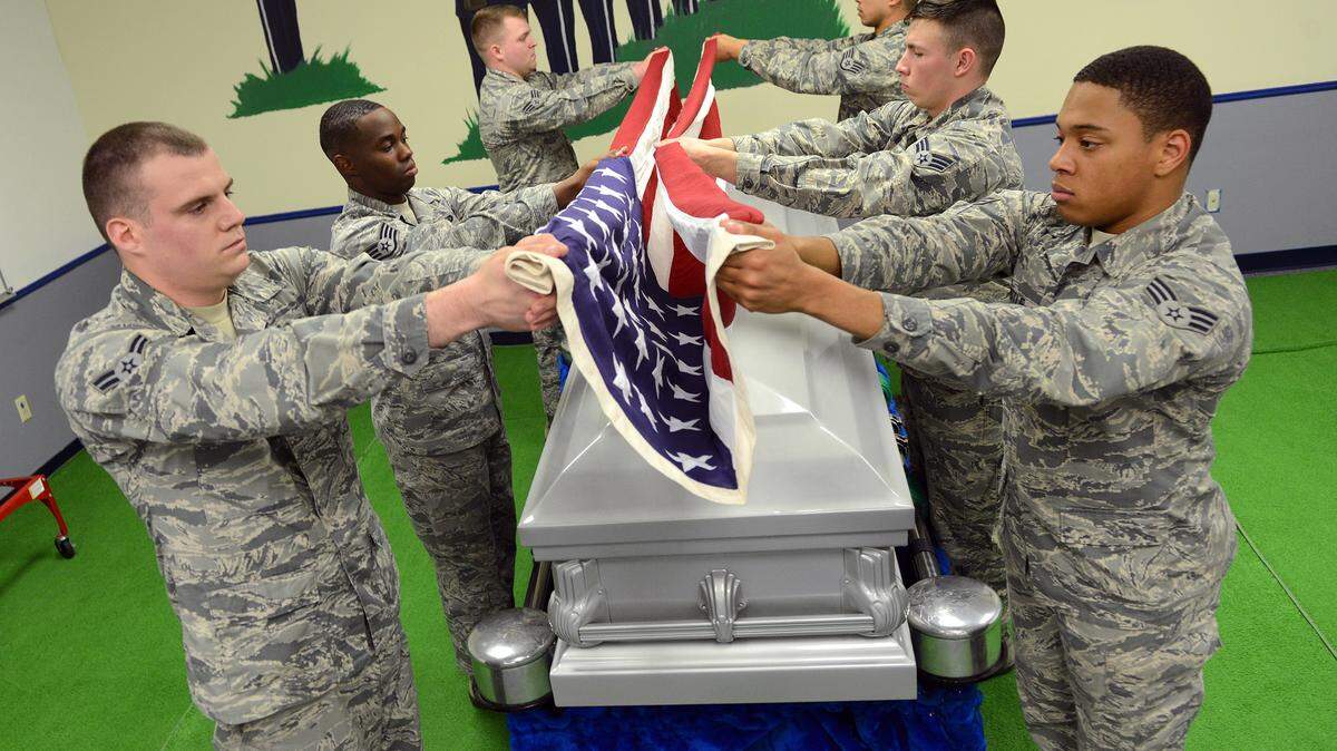 Members of the Robins Honor Guard practice with one of two new caskets, which were donated to the group.
