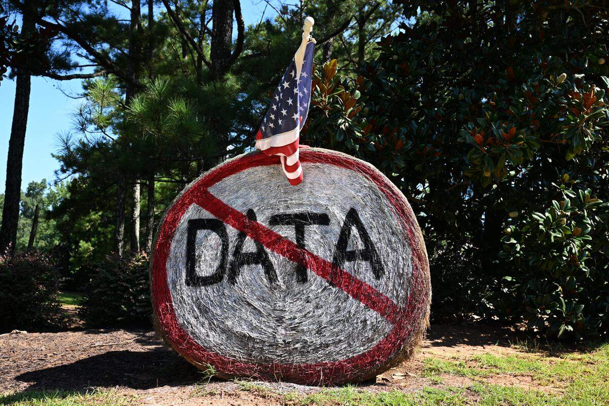 A “No Data” sign painted on a round hay bale sits off of US-41 on Thursday, July 31, 2025, in Bolingbroke, Georgia. The Monroe County Board of Commissioners is set to vote on whether to rezone over 900 acres of land from residential to commercial for a proposed data center at their August meeting. 