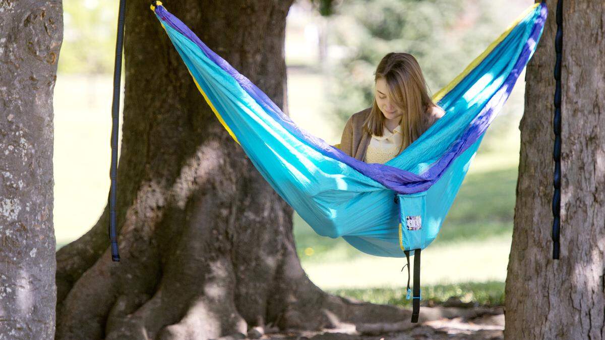 Mercer freshman Krysta Therieau reads a book while laying in a hammock at Tattnall Square Park on Sunday afternoon.