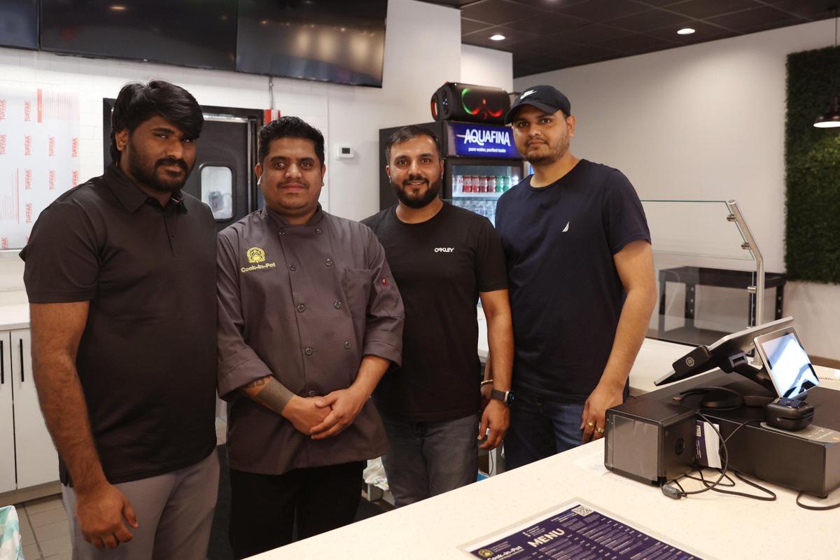 Cook-in-Pot partner Sundeep Bellamkonda (far left), chef Prasad Naik, partner Hitesh Patel and his brother Rishabh Patel pose behind the counter of Cook-in-Pot on Forsyth Street on Tuesday, Feb. 4, 2025, in downtown Macon, Georgia. The new restaurant offers a wide variety of authentic Indian, Mediterranean and Indo-Chinese dishes.