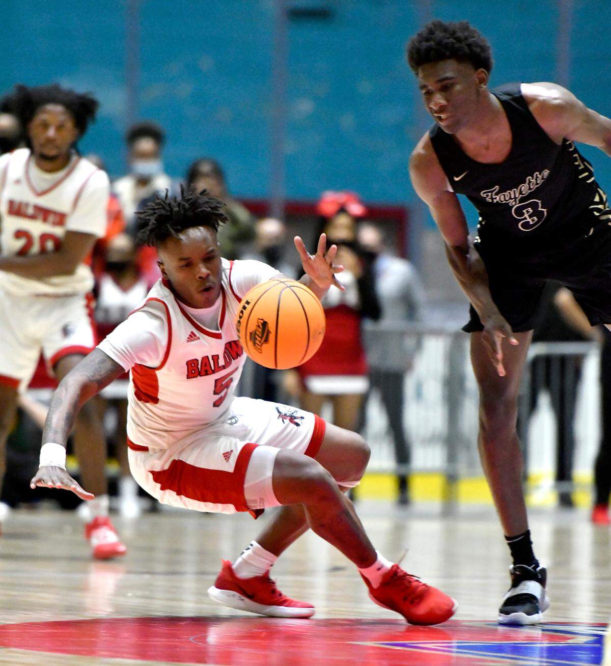 BaldwinÕs Jermyus Simmons (5) loses his balance while scrambling for a loose ball during the BravesÕ GHSA 4A State Championship game against Fayette County Wednesday night in Macon.