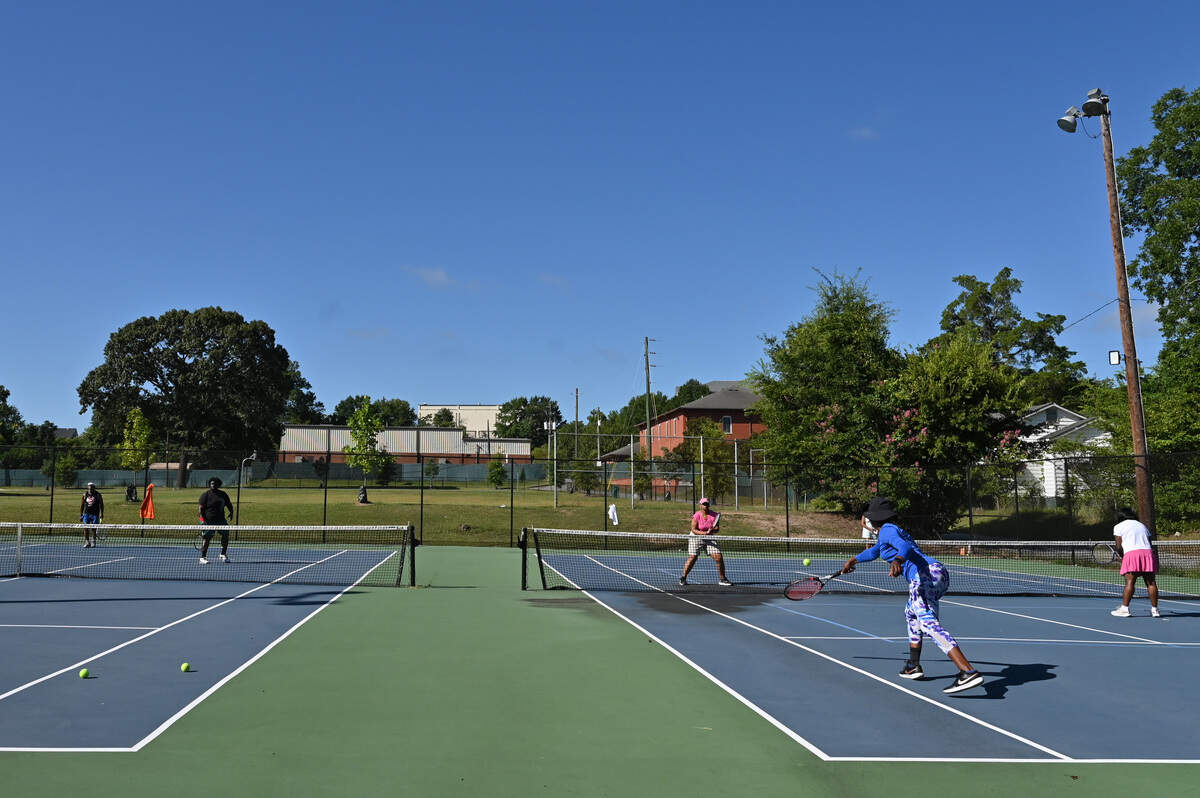 Community members and former members of the Cross-Court Racquet Club play doubles tennis on Saturday, July 26, 2025, at the Mattie-Hubbard Jones Tennis Courts in the Pleasant Hill community in Macon, Georgia. The Cross-Court Racquet Club began in 1975 as a way to bring tennis to the youth of Pleasant Hill and the club hopes that it will begin a new era and provide equipment, professional coaching, and more services.