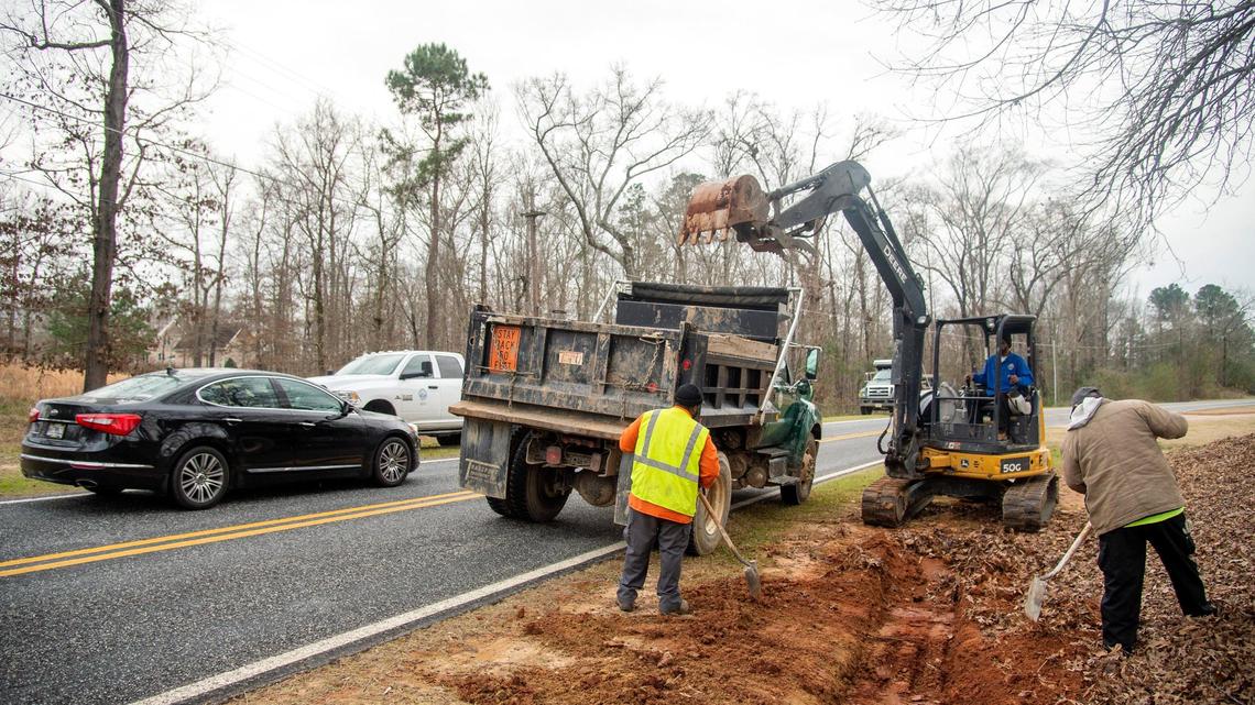 Macon-Bibb County public works employees redirect a ditch along Wesleyan Drive North near the entrance of the Brickyard Golf Club Thursday afternoon. Erosion has caused rain water to run onto the road during storms.