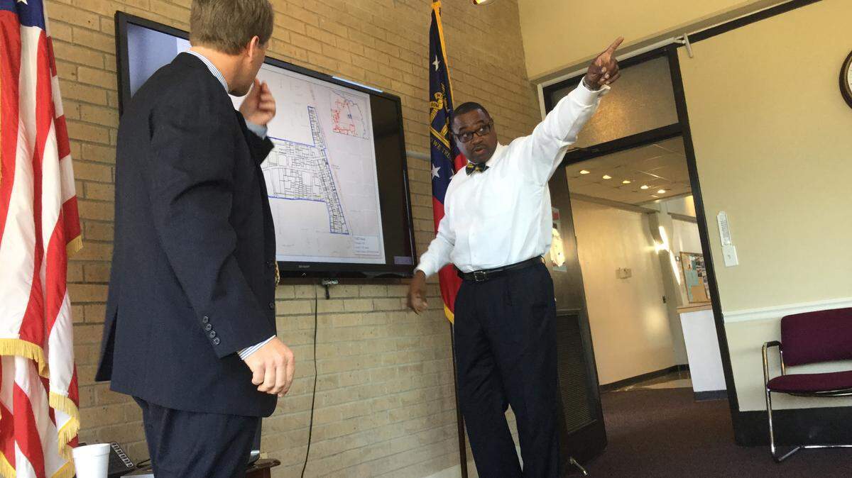Gary Lee, executive director of the Warner Robins Redevelopment Agency at right, asks a question to attorney Blake Sharpton about the draft map of the proposed tax allocation district that was presented to the agency Monday morning.