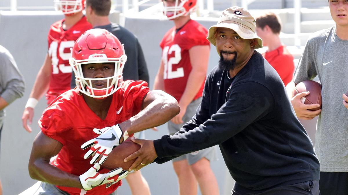 Georgia tailback James Cook (6) works with running backs coach Dell McGee during the Bulldogs’ practice at Sanford Stadium in Athens on Aug. 4.