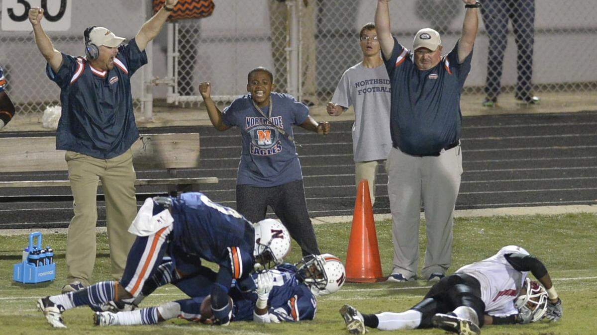Northside backers celebrate after Tae Daley (3) picks off a Warner Robins pass intended for Marquez Callaway (1) with a minute to go in last year's game, won 24-21 by Northside.